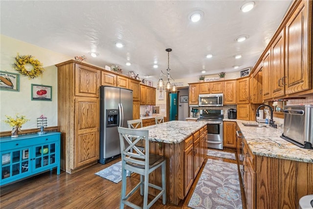 227 Holly Pl, Mount Pleasant Twp Wml, PA 15666 - kitchen with stainless steel appliances, brown cabinetry, light stone countertops, a kitchen island, and recessed lighting