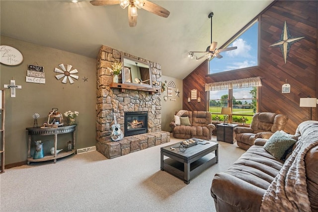 227 Holly Pl, Mount Pleasant Twp Wml, PA 15666 - living area featuring ceiling fan, carpet flooring, a stone fireplace, wood walls, and high vaulted ceiling