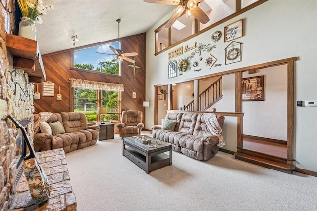 227 Holly Pl, Mount Pleasant Twp Wml, PA 15666 - carpeted living area featuring ceiling fan, wood walls, high vaulted ceiling, and stairway