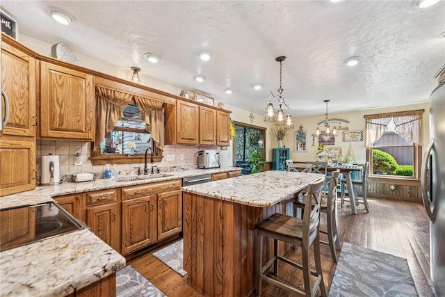 227 Holly Pl, Mount Pleasant Twp Wml, PA 15666 - kitchen with a kitchen island, dark wood-style floors, brown cabinetry, light stone counters, and recessed lighting