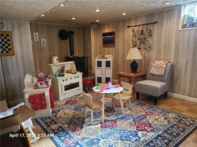 3381 Columbia Dr, Castle Shannon, PA 15234 - rec room with wood walls, a wood stove, tile patterned floors, and track lighting