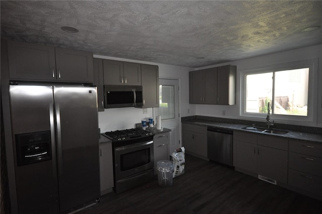 16 4th St, Sharpsburg, PA 15215 - kitchen with appliances with stainless steel finishes, dark countertops, dark wood finished floors, gray cabinetry, and a textured ceiling