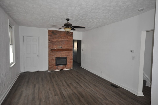 16 4th St, Sharpsburg, PA 15215 - unfurnished living room with dark wood-style flooring, a ceiling fan, a textured ceiling, and a brick fireplace