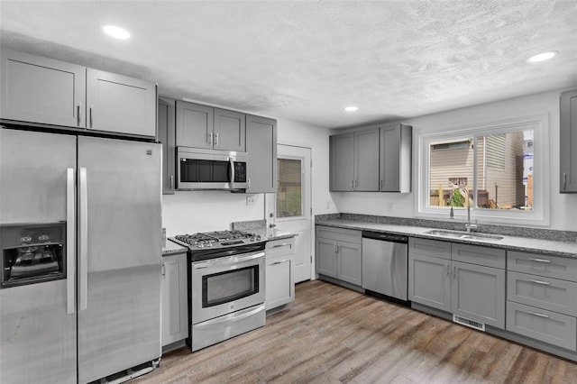 16 4th St, Sharpsburg, PA 15215 - kitchen featuring appliances with stainless steel finishes, gray cabinetry, healthy amount of natural light, recessed lighting, and a textured ceiling