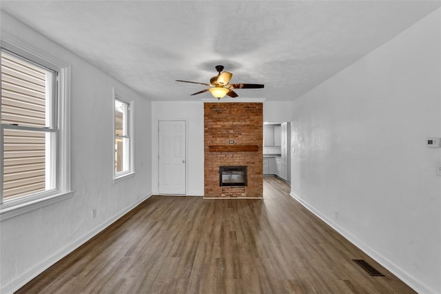 16 4th St, Sharpsburg, PA 15215 - unfurnished living room with dark wood-type flooring, ceiling fan, and a brick fireplace