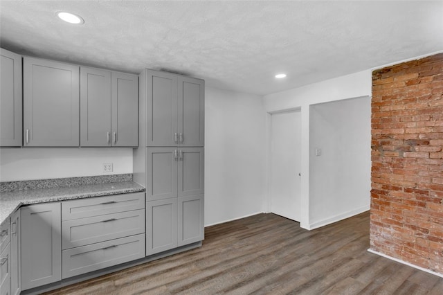16 4th St, Sharpsburg, PA 15215 - kitchen with gray cabinetry, dark wood finished floors, brick wall, recessed lighting, and a textured ceiling