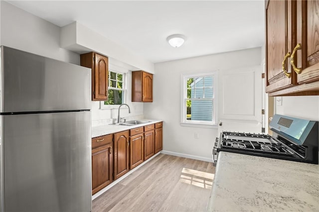 125 Carroll St, Aliquippa, PA 15001 - kitchen with stainless steel appliances, light wood-style floors, and brown cabinetry