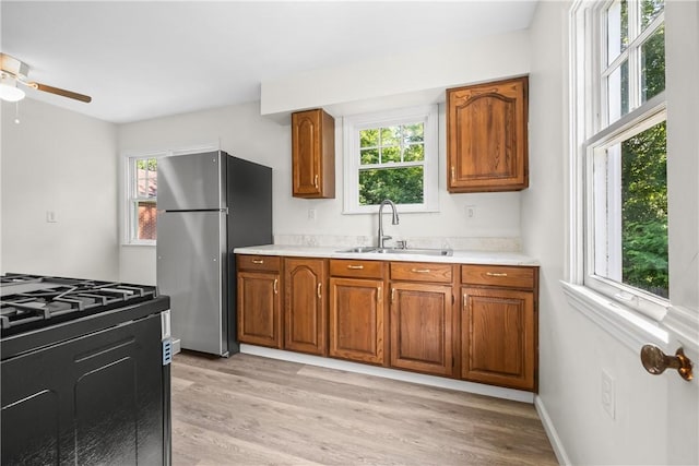 125 Carroll St, Aliquippa, PA 15001 - kitchen featuring freestanding refrigerator, brown cabinetry, ceiling fan, and light countertops