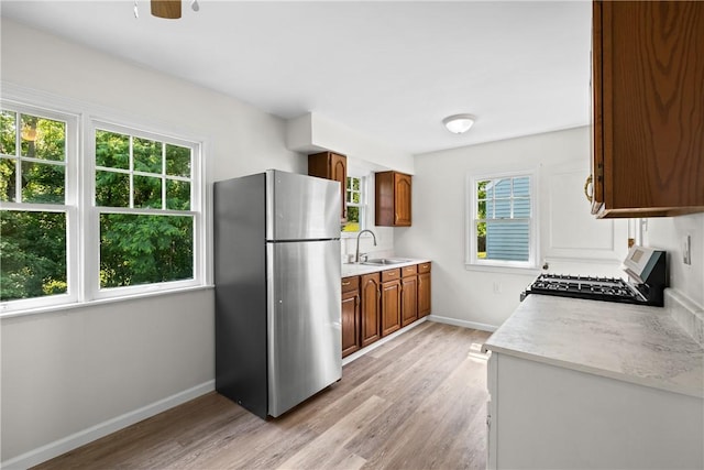 125 Carroll St, Aliquippa, PA 15001 - kitchen featuring freestanding refrigerator, stove, plenty of natural light, and brown cabinetry
