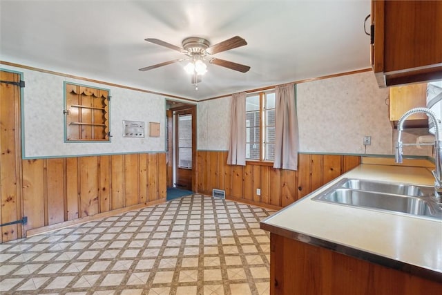 410 Blackhawk Rd, Chippewa Twp, PA 15010 - kitchen featuring a ceiling fan, light floors, a wainscoted wall, wood walls, and ornamental molding
