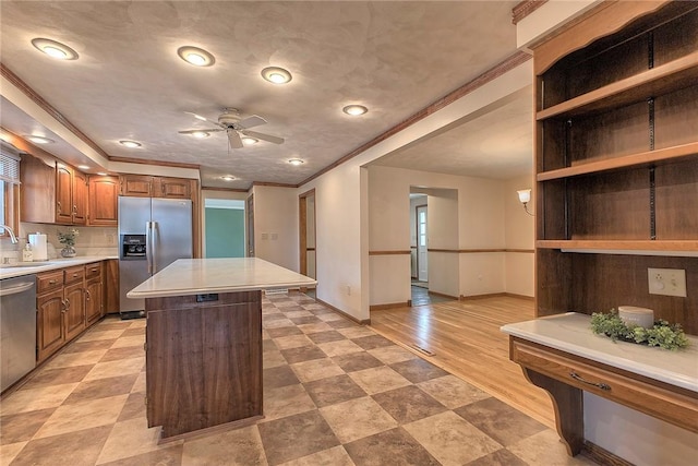 1318 Dellview Dr, Unity Twp, PA 15601 - kitchen featuring stainless steel appliances, a center island, light countertops, ceiling fan, and ornamental molding