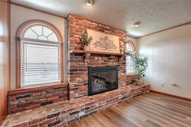 1318 Dellview Dr, Unity Twp, PA 15601 - unfurnished living room with a textured ceiling, ornamental molding, wood finished floors, and a fireplace