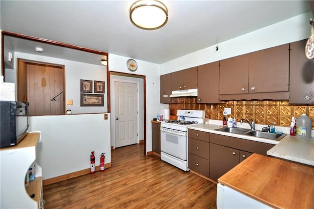 3411 York St, Mckeesport, PA 15132 - kitchen with white gas range oven, under cabinet range hood, decorative backsplash, wood finished floors, and black microwave