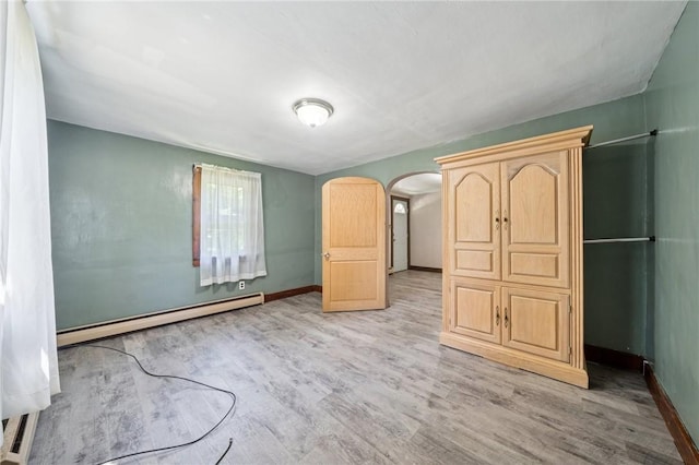 665 Stuchell Rd, Burrel/Blacklick, PA 15748 - unfurnished bedroom featuring a baseboard radiator, light wood-type flooring, and arched walkways