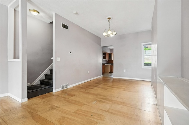 227 Henderson St, Fineview, PA 15212 - spare room featuring light wood-type flooring, a chandelier, stairs, and a smoke detector