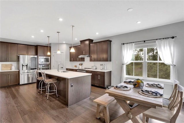 212 Bengal Fox, Jackson Twp, PA 16063 - kitchen featuring appliances with stainless steel finishes, a kitchen island with sink, dark wood-style floors, a breakfast bar, and under cabinet range hood