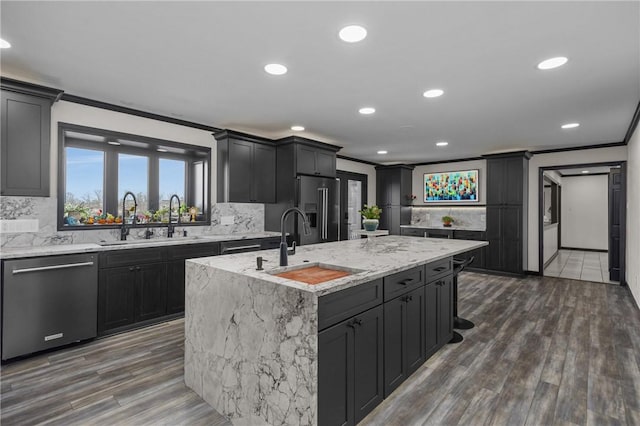 2460 Nicholson Rd, Franklin Park, PA 15143 - kitchen featuring appliances with stainless steel finishes, crown molding, a kitchen island with sink, decorative backsplash, and light stone counters