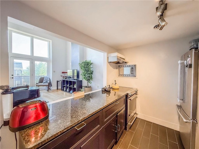 66 Pius St Unit 103, South Side, PA 15203 - kitchen featuring stainless steel appliances, dark stone counters, range hood, a peninsula, and dark brown cabinets