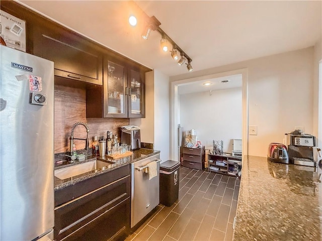 66 Pius St Unit 103, South Side, PA 15203 - kitchen featuring fridge, backsplash, dark stone countertops, glass insert cabinets, and dark brown cabinets