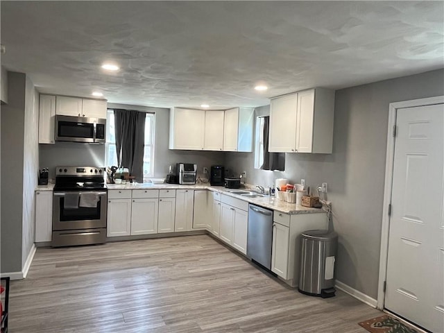 2103 Vermont Ave, West Mifflin, PA 15122 - kitchen featuring appliances with stainless steel finishes, white cabinets, recessed lighting, and light wood-type flooring