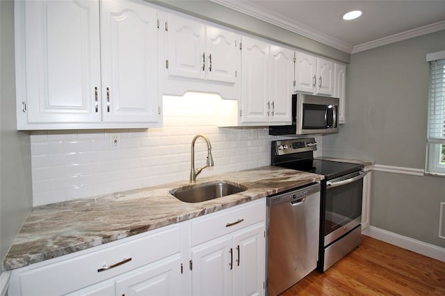 1351 Sky Ridge Dr, Upper St Clair, PA 15241 - kitchen featuring appliances with stainless steel finishes, decorative backsplash, light stone countertops, white cabinetry, and ornamental molding
