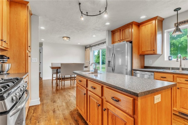 1659 Hooker Rd, Pa, PA 16041 - kitchen with stainless steel appliances, dark countertops, an island with sink, light wood-style flooring, and brown cabinets
