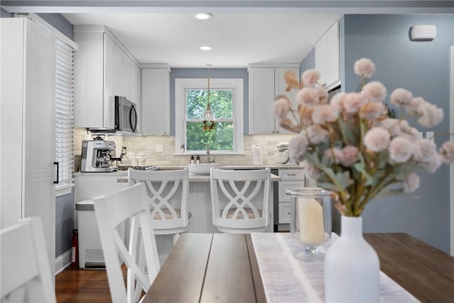727 Vermont Ave, Mt Lebanon, PA 15234 - kitchen with stainless steel microwave, light countertops, backsplash, recessed lighting, and decorative light fixtures