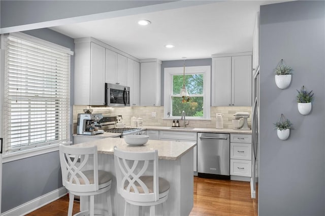 727 Vermont Ave, Mt Lebanon, PA 15234 - kitchen with appliances with stainless steel finishes, a peninsula, tasteful backsplash, a breakfast bar area, and recessed lighting