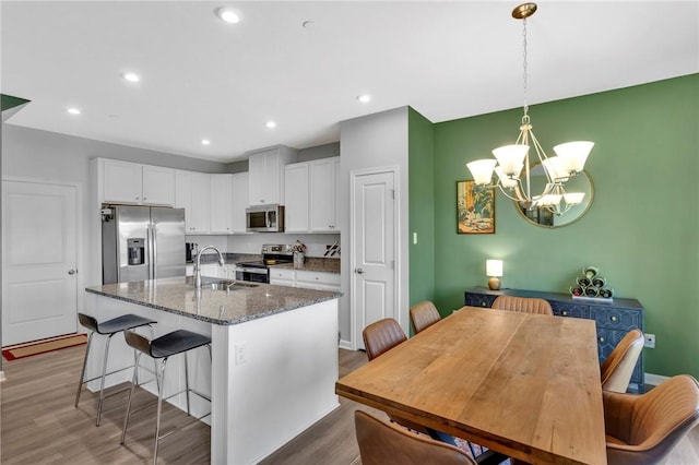 1006 Callaway Dr, Jeannette, PA 15644 - kitchen featuring appliances with stainless steel finishes, a chandelier, white cabinets, wood finished floors, and recessed lighting