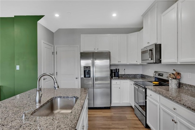1006 Callaway Dr, Jeannette, PA 15644 - kitchen with stainless steel appliances, white cabinets, recessed lighting, wood finished floors, and light stone counters