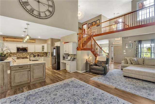 245 Shaw Ct, Salem Twp Wml, PA 15670 - living area featuring a towering ceiling, stairway, wood finished floors, a chandelier, and recessed lighting