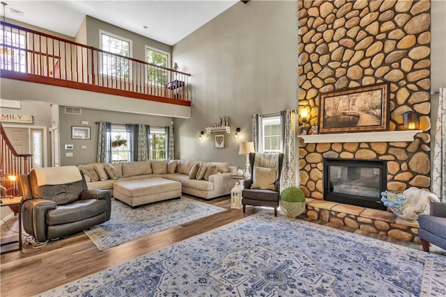 245 Shaw Ct, Salem Twp Wml, PA 15670 - living room with high vaulted ceiling, wood finished floors, a fireplace, healthy amount of natural light, and stairs