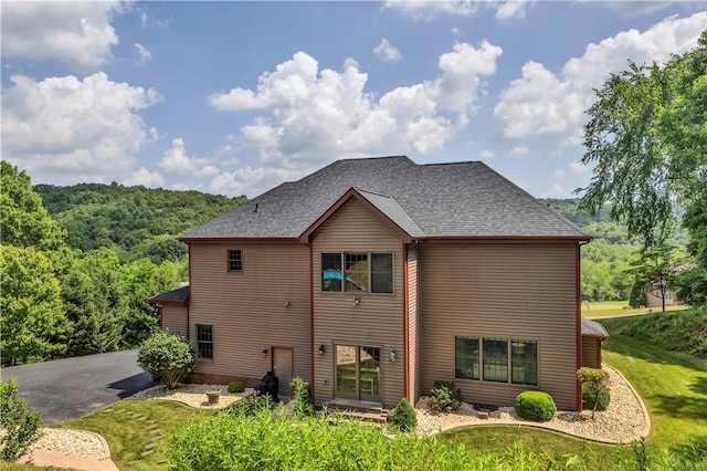 245 Shaw Ct, Salem Twp Wml, PA 15670 - rear view of house with roof with shingles, a yard, and a view of trees