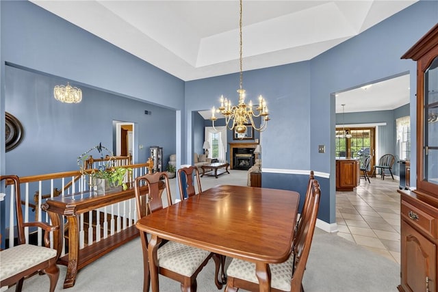 260 Arrowhead Ln, Nottingham, PA 15330 - dining space featuring a chandelier, light tile patterned flooring, a glass covered fireplace, and light colored carpet