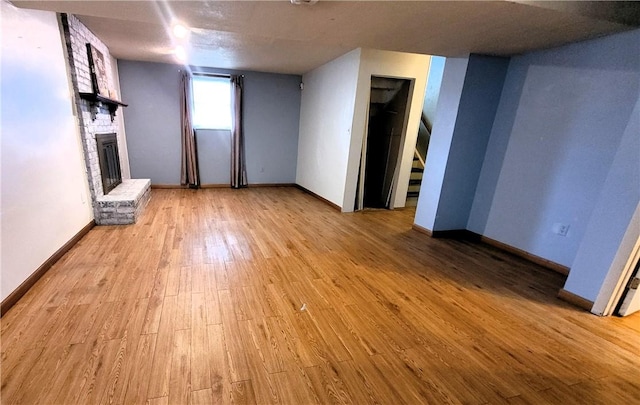 314 Wren Dr, Hempfield Twp Wml, PA 15601 - unfurnished living room featuring wood finished floors, a fireplace, and stairway