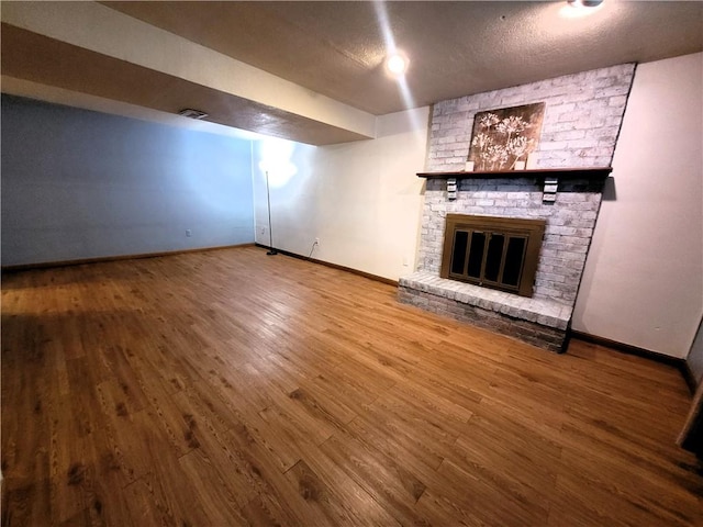 314 Wren Dr, Hempfield Twp Wml, PA 15601 - unfurnished living room featuring wood finished floors, a fireplace, and a textured ceiling