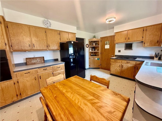 1180 Sunset Dr, Latrobe, PA 15650 - kitchen with black appliances, light floors, and brown cabinetry