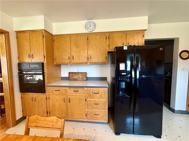 1180 Sunset Dr, Latrobe, PA 15650 - kitchen with black appliances, brown cabinetry, and light flooring