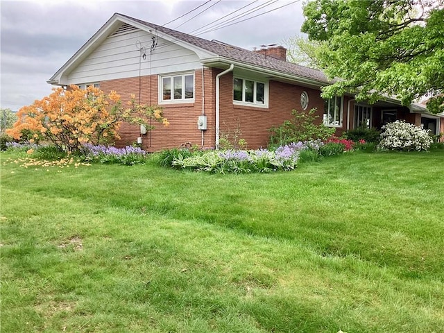 1180 Sunset Dr, Latrobe, PA 15650 - view of home's exterior with a chimney, brick siding, and a yard