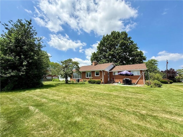 1180 Sunset Dr, Latrobe, PA 15650 - back of house with a lawn, brick siding, a patio area, and a chimney