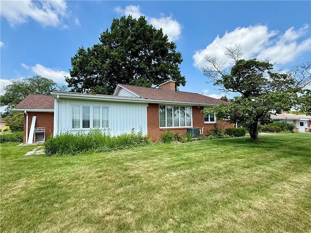 1180 Sunset Dr, Latrobe, PA 15650 - view of property exterior featuring a chimney, brick siding, a yard, and board and batten siding