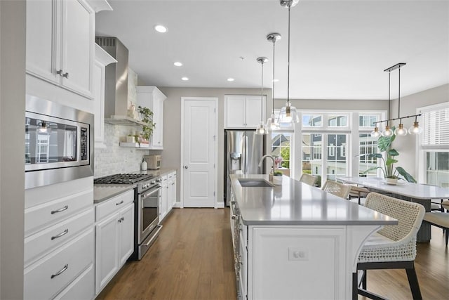 2123 Westcott Ln, South Fayette, PA 15017 - kitchen with appliances with stainless steel finishes, wall chimney exhaust hood, a center island with sink, healthy amount of natural light, and recessed lighting
