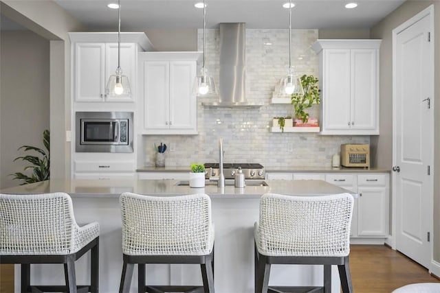 2123 Westcott Ln, South Fayette, PA 15017 - kitchen with stainless steel microwave, wall chimney range hood, light countertops, backsplash, and recessed lighting