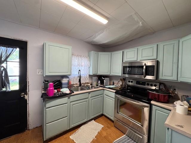 909 N Hickory St, Scottdale, PA 15685 - kitchen with appliances with stainless steel finishes and light wood-style floors