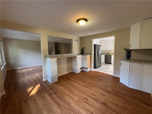 111 Hemlock Ln, Monroeville, PA 15146 - kitchen with stainless steel appliances, white cabinets, light wood-style flooring, and light stone countertops