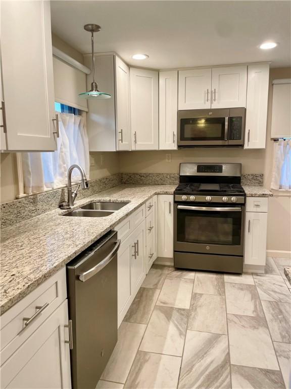 111 Hemlock Ln, Monroeville, PA 15146 - kitchen with stainless steel appliances, white cabinets, recessed lighting, pendant lighting, and light stone counters
