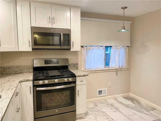 111 Hemlock Ln, Monroeville, PA 15146 - kitchen with stainless steel appliances, white cabinetry, light marble finish flooring, light stone countertops, and decorative light fixtures