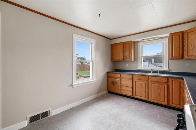 1029 Nimick Ave, Monaca, PA 15061 - kitchen featuring crown molding, brown cabinets, dark countertops, and stove