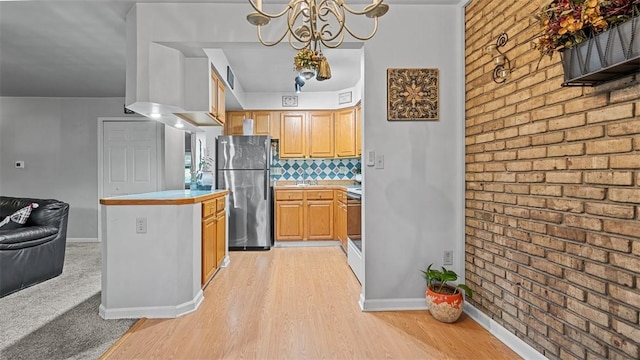 6108 Sanlin Dr, Moon/Crescent Twp, PA 15108 - kitchen featuring freestanding refrigerator, brick wall, light wood-type flooring, a chandelier, and tasteful backsplash