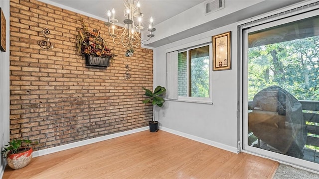 6108 Sanlin Dr, Moon/Crescent Twp, PA 15108 - dining room with a chandelier, brick wall, and wood finished floors